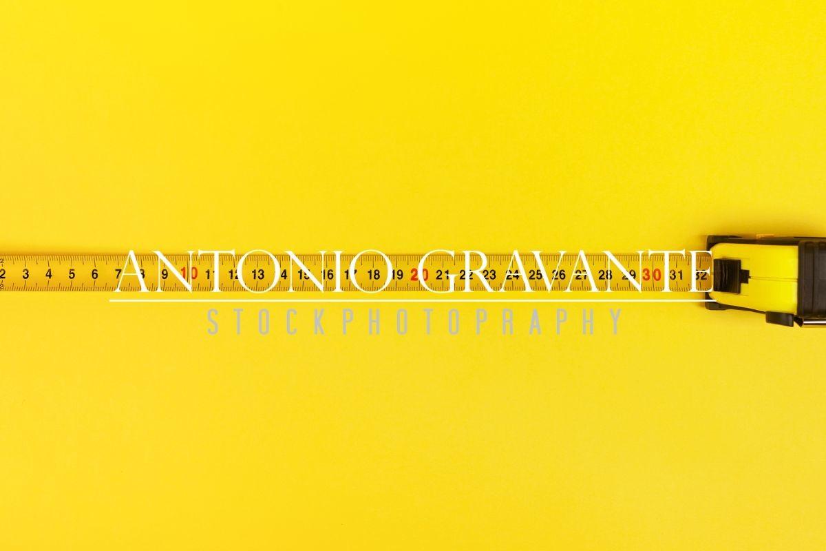 Yellow Measuring Tape on Yellow Background