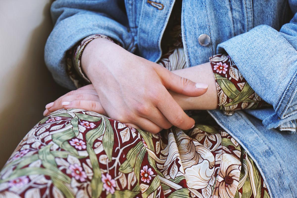 Midsection of Young Woman Wearing Denim Jacket over Summer Dress with Floral Pattern