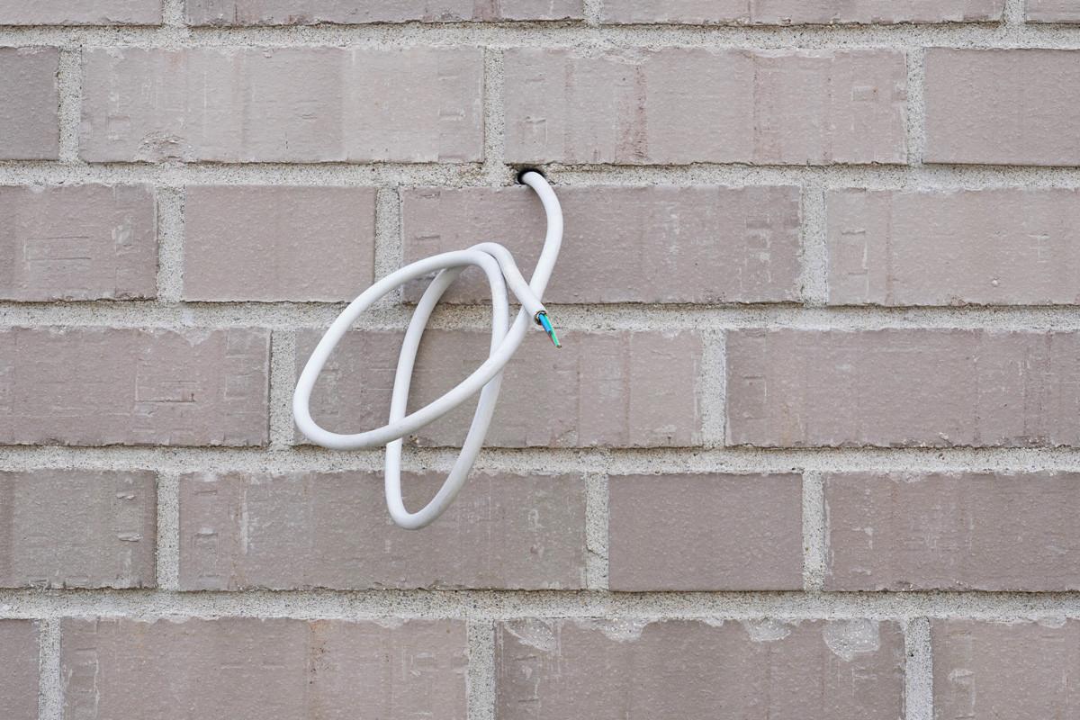 Electrical Wire or Power Cable Hanging from Exterior Wall